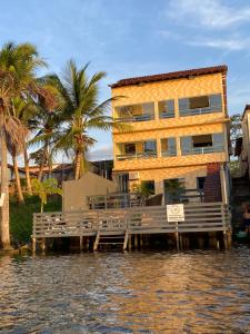 une maison sur un quai dans l'eau dans l'établissement Pousada Casa do Professor, à Barreirinhas