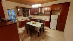 een keuken met een tafel met stoelen en een koelkast bij WoodHouse in Markopoulon