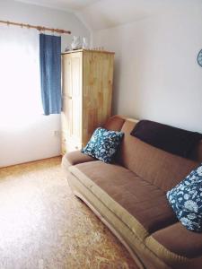 ein Wohnzimmer mit einem braunen Sofa und einem Fenster in der Unterkunft Sklep U Petra in Velké Bílovice