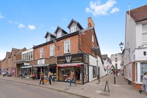 a street with shops and people walking down the street at Town center apartment in Bishops Stortford in Birchanger