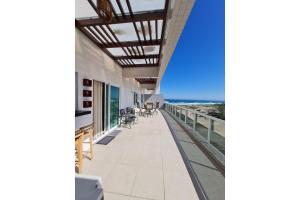 a balcony with chairs and a view of the ocean at Arraial do Cabo. Cobertura Espetacular c Vista Mar in Arraial do Cabo