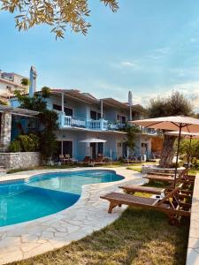 un resort con piscina con panchine e ombrellone di Sunny Place Resort Kilada a Kilada