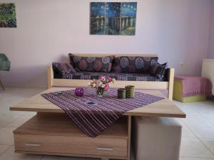 uma sala de estar com uma mesa e um sofá em Mauve Apartment em Argostólion