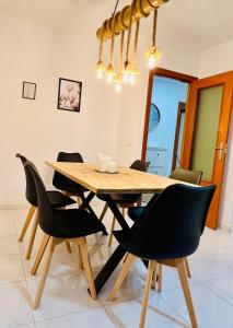 mesa de comedor con sillas negras y lámpara de araña en Apartamento Sant Roc, en Benidorm