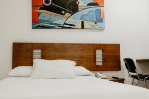 a bedroom with a bed and a painting on the wall at Hotel Barrancabermeja Plaza in Barrancabermeja +26 photos