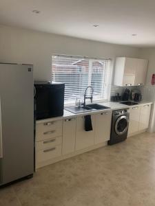 a kitchen with a sink and a washing machine at HALLSTEAD in Skegness