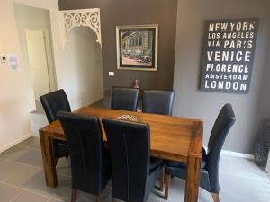 comedor con mesa de madera y sillas negras en Elmsford Cottage, en Warragul 5 fotos más