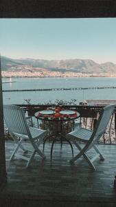 a table and chairs on a patio with a view of the water at Escape to History in a Stunning Stone House with Garden and Sea View in the Heart of Alanya in Alanya