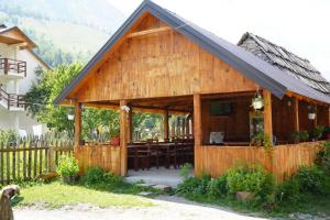 un gran edificio de madera con bar en Guesthouse Skender Selimaj en Valbonë