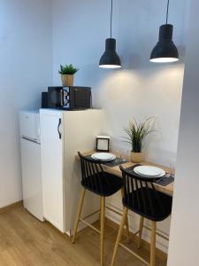 a kitchen with a table with chairs and a refrigerator at Precioso loft en centro histórico de Melilla in Melilla