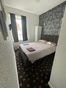 a small bedroom with a bed and a window at Sam Residence Hotel in Blackpool