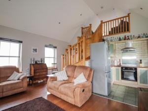 a living room with a couch and a refrigerator at Ridge End Cottage in Kilmaluag