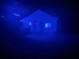 a house with a blue light in the dark at Cabin with Hot Tub in Aberdeenshire in Gamrie