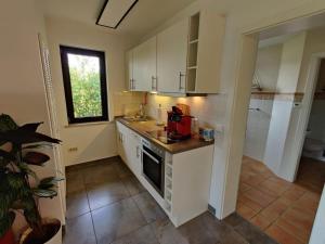 a kitchen with white cabinets and a red appliance at Haus Wehner in Stadtoldendorf