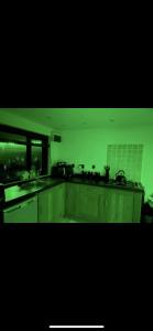 a kitchen with white cabinets and a green background at Cabin with Hot Tub in Aberdeenshire in Gamrie