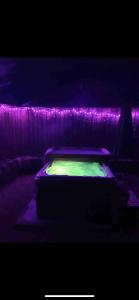 a bed in a room with purple lights at Cabin with Hot Tub in Aberdeenshire in Gamrie