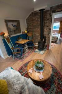 uma sala de estar com uma mesa e um fogão a lenha em The Loveshack Lodge Balquhidder em Balquhidder