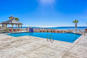 a swimming pool with a gazebo and the beach at Escapes! To The Shores #204 in Orange Beach