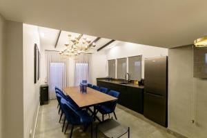 a kitchen and dining room with a table and blue chairs at שירת צפת in Safed