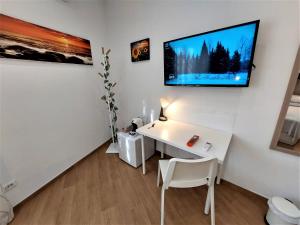 ローマにあるTrustEverVitoの白いデスク、壁掛けテレビが備わる客室です。