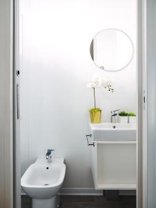 Baño blanco con lavabo y espejo en Sentido Punta Marina Premium Pini, en Punta Marina