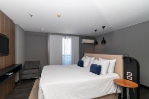 a bedroom with a large bed and a television at Suite Particular Brasília in Brasilia