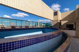 a swimming pool on the side of a building at Suite Particular Brasília in Brasilia
