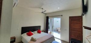 una camera da letto con un letto con cuscini rossi di Carri Surf Studio a Puerto Escondido