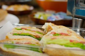 un sandwich coupé en moitié sur une plaque dans l'établissement Frimas Hotel, à Belo Horizonte