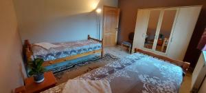 um pequeno quarto com 2 camas e um espelho em Nazareth logement em Bastogne