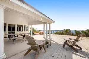 芬威克島的住宿－Salt Meadows - 40146 Salt Meadows，海滩上带椅子和野餐桌的门廊