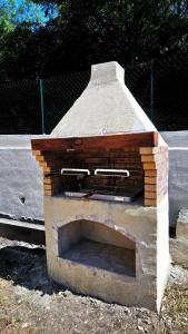 a brick oven sitting next to a fence at Appartement 48 m2 avec jardin au rdc dans villa à 5 min à pied des Thermes de Vernet-les-Bains, location de samedi à samedi in Vernet-les-Bains