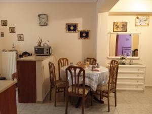 a dining room with a table and chairs and a kitchen at Sweet Home in Volos