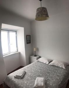a bedroom with a bed with two towels on it at Costa House in Nazaré