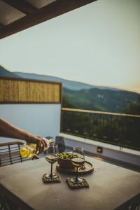 einen Tisch mit zwei Weingläsern und einer Obstschale in der Unterkunft Peri Elxis Luxury Suites in Mouresi