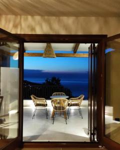 a glass door leading to a patio with a table and chairs at Peri Elxis Luxury Suites in Mouresi