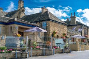 a brick building with umbrellas in front of it at Rogerthorpe Manor Hotel in Pontefract +19 photos