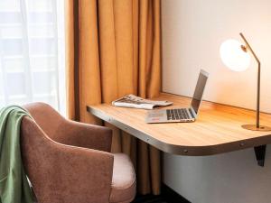 a desk with a laptop and a chair on it at Mercure Amsterdam North Station in Amsterdam