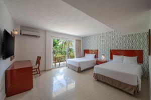 una camera d'albergo con due letti e una televisione di Hotel Dos Playas Faranda Cancún a Cancún