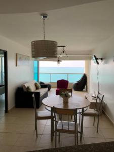 uma sala de estar com uma mesa e um sofá em Departamento en Torre Oceanica em Salinas