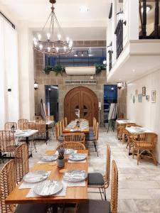 a restaurant with wooden tables and chairs and a chandelier at Anex Hotel near US Embassy in Manila