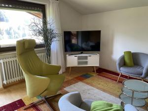 Televízia a/alebo spoločenská miestnosť v ubytovaní Gruppenferienwohnung am Auweg