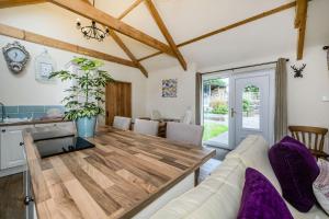 a kitchen and dining room with a wooden table at Warbrook in Sutcombe