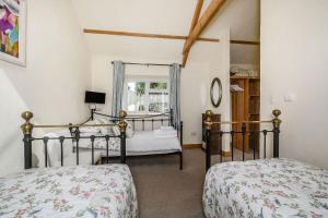 a bedroom with two beds and a window at Warbrook in Sutcombe