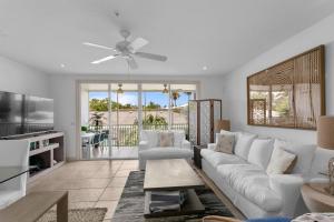 a living room with a white couch and a ceiling fan at Bradenton Beach Club #13 in Bradenton Beach