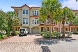 a large house with palm trees in front of it at Bradenton Beach Club #13 in Bradenton Beach