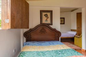 a bedroom with a bed with a wooden head board at Alojamiento Rural Finca El Rubi- Eje cafetero in Quimbaya