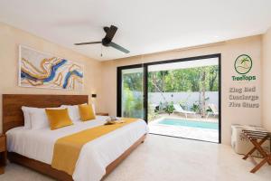 a bedroom with a bed and a swimming pool at Suites at TreeTops Tulum in Tulum
