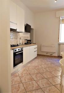 uma cozinha com armários brancos e piso em azulejo em Bologna Apartment em Bolonha
