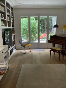 a living room with a piano and a table at MAISON STANDING et SYMPA PROCHE ROLAND GARROS et MÉTRO in Boulogne-Billancourt